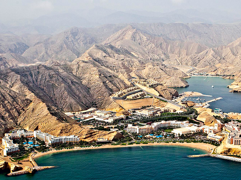 The resort sits on the coast, framed by rugged mountains
